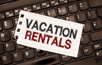 Piece of paper that reads, "Vacation Rentals" atop keyboard.
