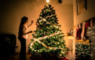 Woman decorating Christmas tree.