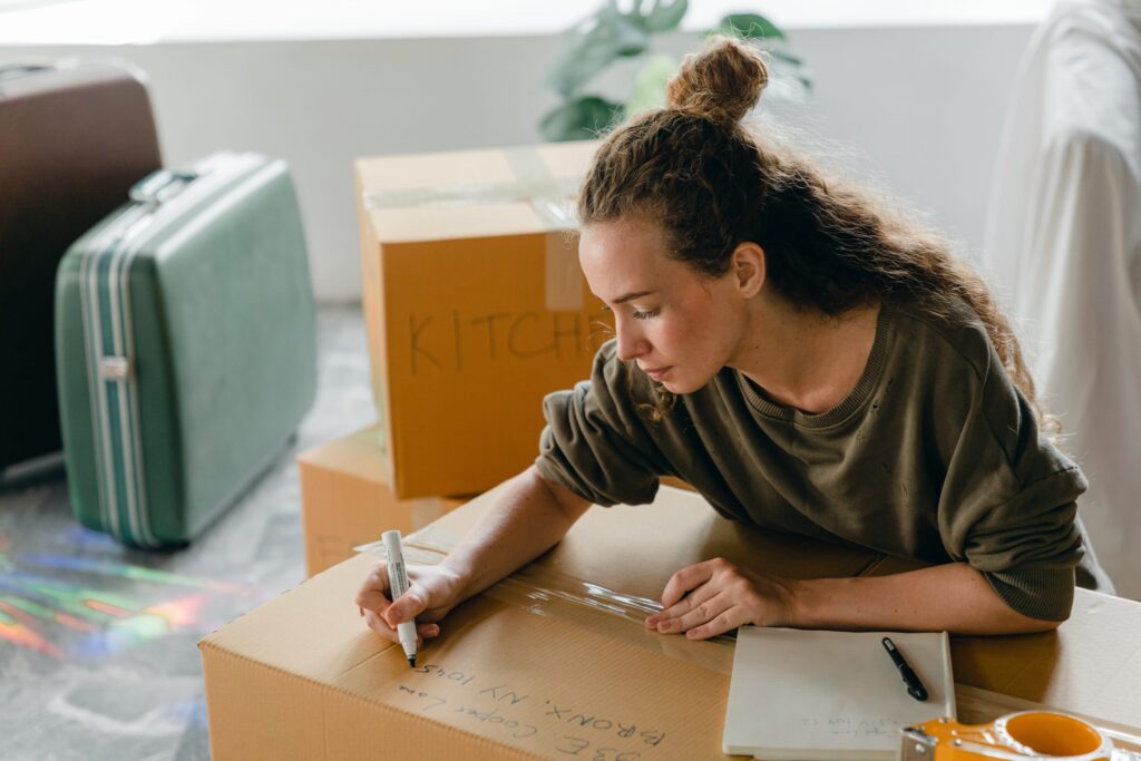 Woman labeling packing boxes.