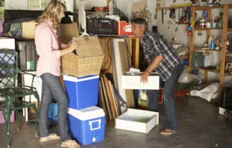 Man and woman cleaning garage.